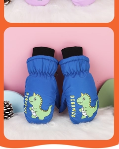 Close-up of blue waterproof winter mittens with cartoon dinosaur print on white plush surface