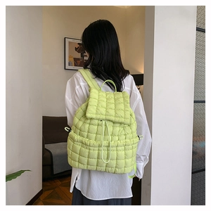 Close-up of light green quilted puffy backpack with soft ruffled texture details