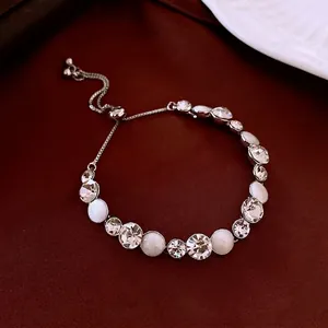 Adjustable silver bracelet featuring crystal zircons and milky cat eye stones on silk