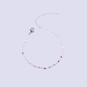 Detail of silver stainless steel chain bracelet with pink enamel oval charms and lobster clasp