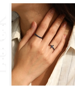 Detail of S925 sterling silver ring with blue zircons and cross design on a model