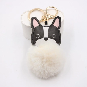 Detail of French Bulldog pompom keychain with golden lobster clasp and white fluffy fur ball
