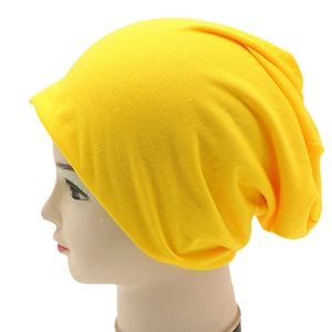 Detail of yellow slouchy knit beanie on a mannequin head showing drape and fabric texture