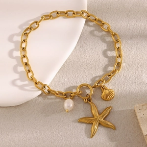 Detail of 18K gold-plated anklet featuring starfish, pearls, and shells on a beige background
