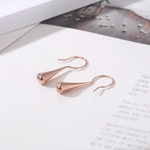 Elegant rose gold teardrop hook earrings with polished finish on minimalist paper background