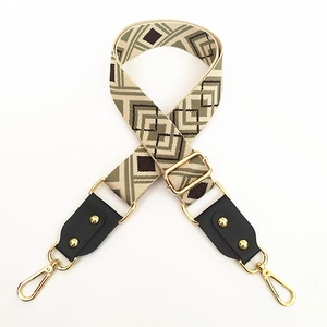 Detail of adjustable geometric diamond pattern wide canvas strap with gold metal hooks