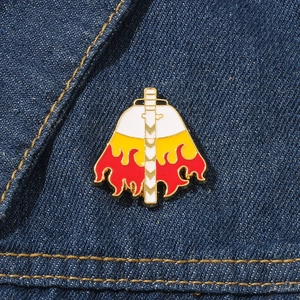 Broche en émail avec motif de cape et d'épée sur fond de tissu en jean bleu