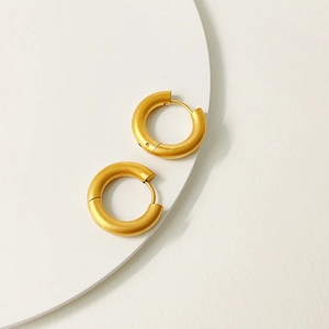 Detail showing the inner S.STEEL engraving on gold-plated matte hoop earrings