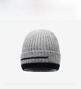 Detailed view of grey winter knit beanie with thick ribbed texture and blue accent stripes