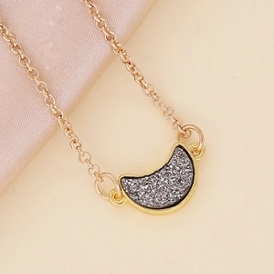 Minimalist gold moon necklace with dark grey sparkling acrylic pendant on silk