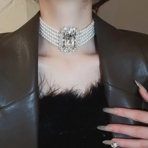 Detail of multi-strand pearl and crystal necklace worn by a model in luxury attire