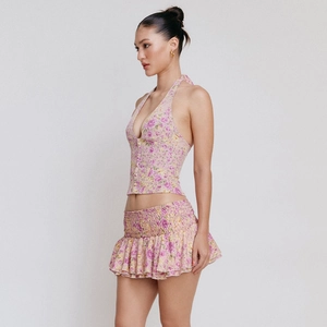 Detail of pink floral halter top with buttons and ruffled mini skirt with smocked waist