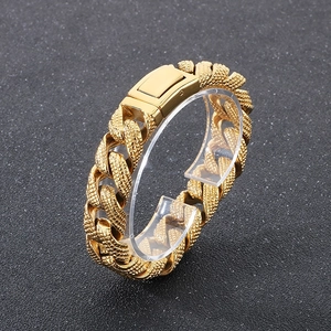 Detailed macro view of 15mm gold Cuban link bracelet with unique granular anti-slip texture