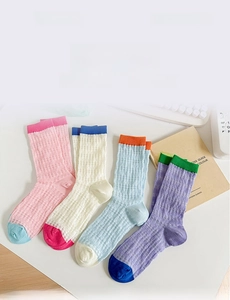Détail de chaussettes en résille multicolores avec motifs à rayures contrastées et tissu respirant