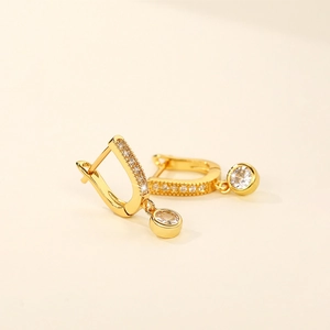 Detail of gold-plated hoop earrings featuring micro-pave zircons and round drops