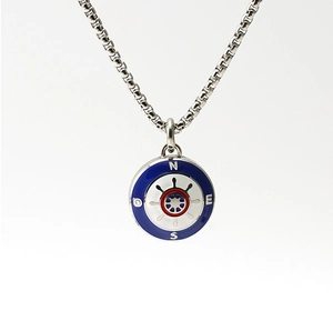 Close-up of nautical compass pendant with blue enamel, red rudder, and box chain detail