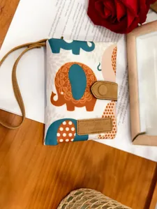 Close-up of matte canvas trifold wallet with colorful elephant patterns and leather snap