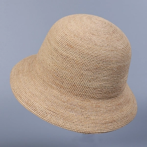 Detailed view of hand-woven raffia straw hat with elegant dome shape and fine texture