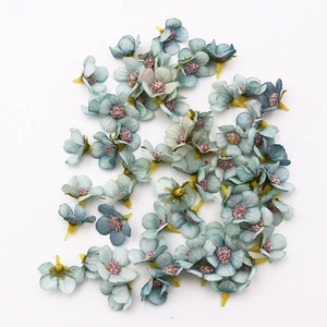 Detailed view of 2cm blue silk daisy heads with yellow stamens for DIY craft decor