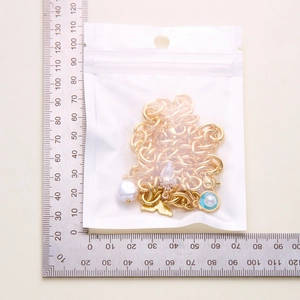 Detail shot of ocean theme necklace with starfish and pearl pendants in a 7x7cm package