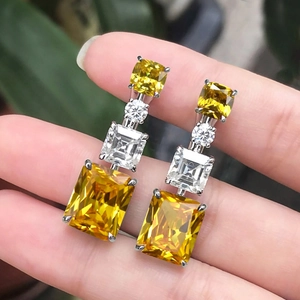Elegant long geometric earrings with emerald-cut yellow and white gemstones in silver setting