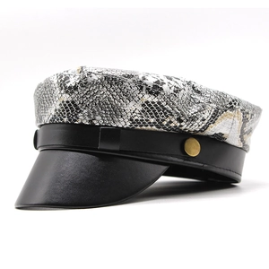 Detail of snakeskin print pattern with black faux leather brim and gold metal button