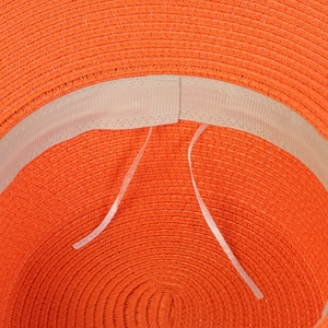 Detail of the orange straw hat showing internal beige sweatband and adjustable drawstring