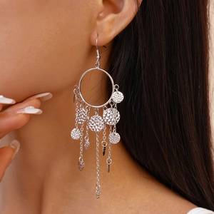Boucles d'oreilles créoles argentées avec pampilles martelées portées par un mannequin
