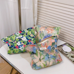 Detailed macro view of three cotton floral cosmetic bags with vintage oil painting patterns