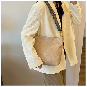 Detail of light khaki bucket bag with ethnic embroidered wide strap for women
