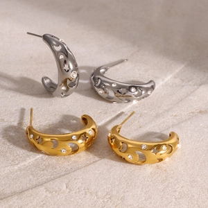 Detailed view of gold and silver hollow star-moon earrings with crystal rhinestones