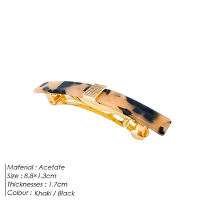 Detail of tortoise shell acetate hair clip with gold metal spring and crystal inlay