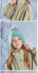 Detail of colorful knit beanie with faux fur pom pom and warm fleece lining for kids