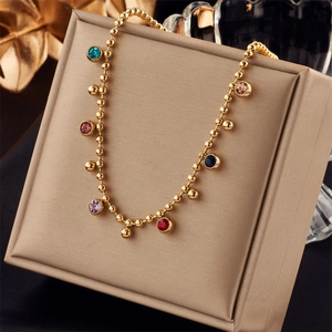 Detailed macro view of gold bead chain necklace featuring seven vibrant colorful gemstones