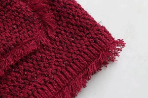 Détail du tissu tweed bordeaux avec fils métalliques argentés et bords à franges élégants