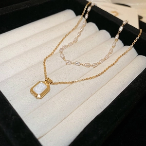 Macro detail of French vintage double layer necklace with gold pendant and rice pearls