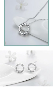 Detailed view of silver necklace and earrings set with LIFE FANTASTIC engraving and zircons