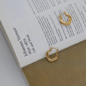 Macro detail of textured horseshoe earrings in 18K gold plated vintage chain style