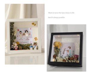 Detail of DIY shadow box with LED lights, dried flowers, and wedding figurines