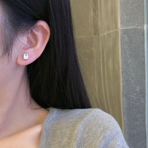 Close-up of S925 sterling silver square zircon stud earring worn on a female earlobe