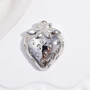 Detailed macro view of a polished silver metal strawberry pendant with realistic textures