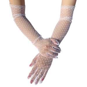 Close-up of white mesh gloves with vintage polka dots and delicate lace texture
