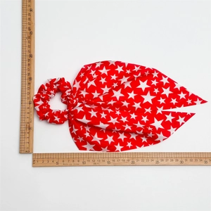 Red Independence Day hair scrunchie with white star pattern and streamers on white background
