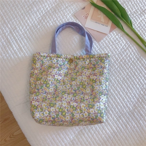 Detail of floral canvas lunch bag showing soft purple handle and gold snap closure