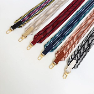 Macro detail of colorful patterned fabric bag straps with golden metal lobster clasps