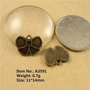 Macro shot of 11x14mm bronze bow pendant for DIY jewelry making with dimensions