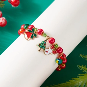 Detail of Christmas beaded bracelet with Santa and bell charms on a festive background