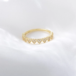 Macro view of gold heart-shaped zircon eternity ring with S925 silver stamp detail