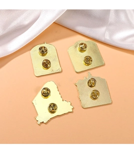 Detail of golden metal fridge magnets back side with secure butterfly clasp closures