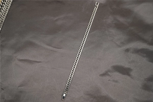Vista dettagliata di un classico bracciale a catena cubana argento su raso scuro